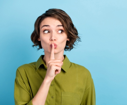 a woman placing a finger on her lips