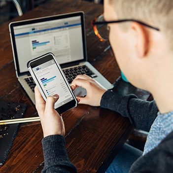 Business person using their phone and laptop.