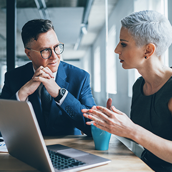 Two business people meeting at a laptop.