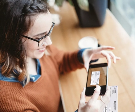 a woman taking a photo of a paper check